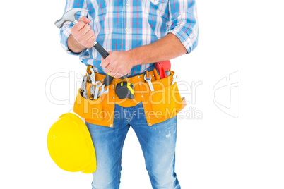 Midsection of manual worker holding hammer Midsection of manual worker holding hammer