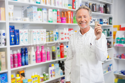 Senior pharmacist holding medicine jar