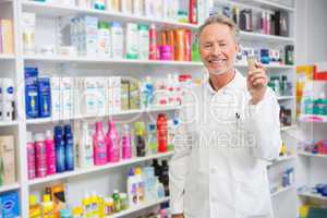 Senior pharmacist holding medicine jar