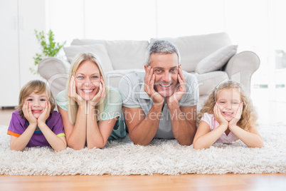 Parents and children with head in hands lying on rug