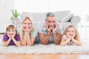 Parents and children with head in hands lying on rug