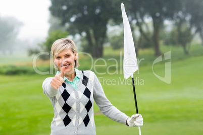 Lady golfer holding flag