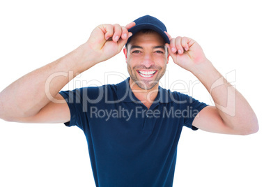 Smiling delivery man wearing cap on white background