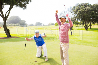 Golfing friends cheering on the putting green