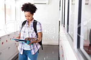 Young woman reading folder in office