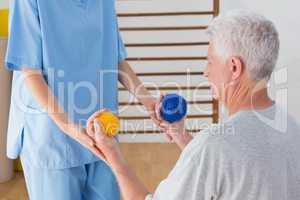 Senior man working out with his therapist