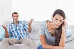 Woman suffering from headache while man quarreling