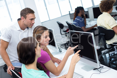Computer teacher helping pretty female students