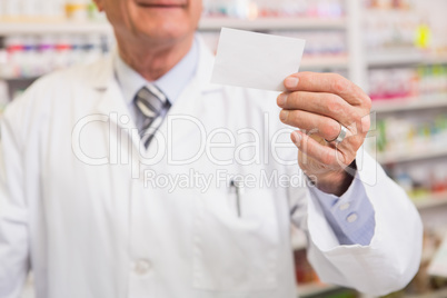 Senior pharmacist reading calling card