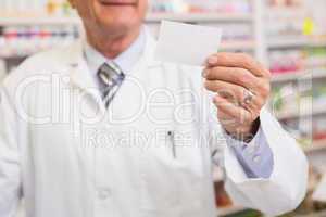 Senior pharmacist reading calling card