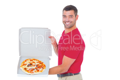 Delivery man showing fresh pizza on white background