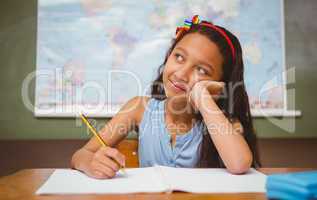 Girl writing book in classroom