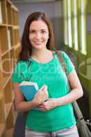 Student smiling at camera in library