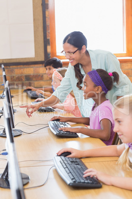 Cute pupils in computer class with teacher