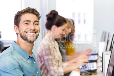 Student smiling at camera in computer class