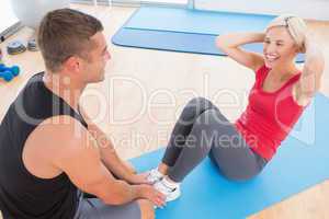 Woman working on exercise mat with her trainer