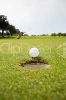 Golf ball at the edge of the hole