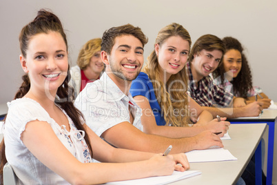 Students writing notes in classroom