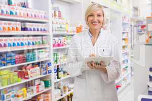 Smiling pharmacist writing on clipboard