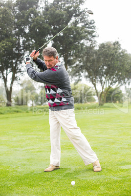 Golfer swinging his club on the course