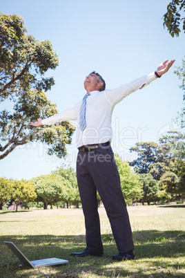 Businessman feeling free in the park