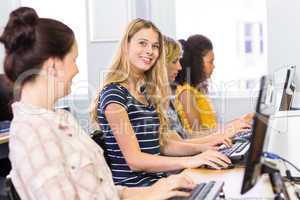 Student smiling at camera in computer class