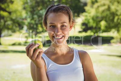 Fit woman holding green apple