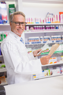 Smiling senior pharmacist holding prescription