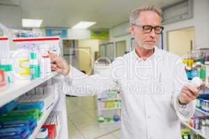 Concentrated pharmacist looking at medicine
