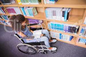 Smiling disabled student in library reading book