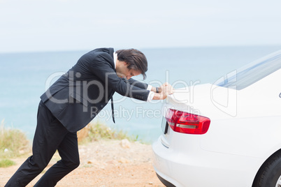 Businessman pushing his car