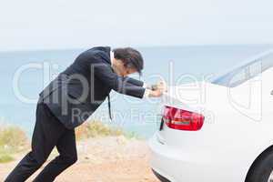 Businessman pushing his car