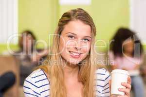 Casual young woman holding disposable cup