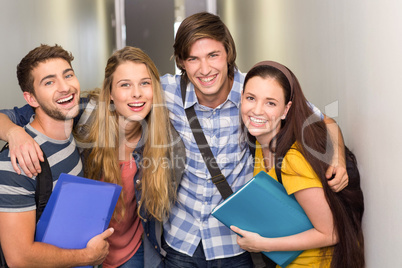 Students holding folders at college corridor