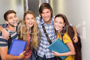 Students holding folders at college corridor