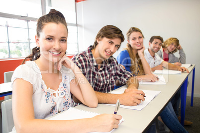 Students writing notes in classroom