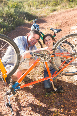 Father and son repairing bike together