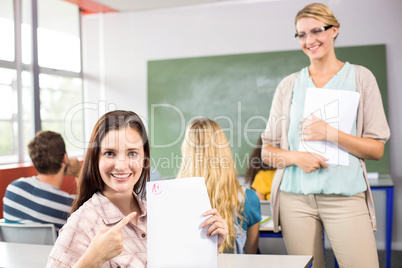 Beautiful female student pointing at paper