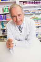 Smiling senior pharmacist holding medication