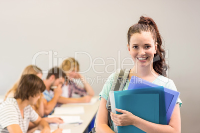 Happy female student holding folders