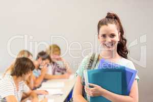 Happy female student holding folders