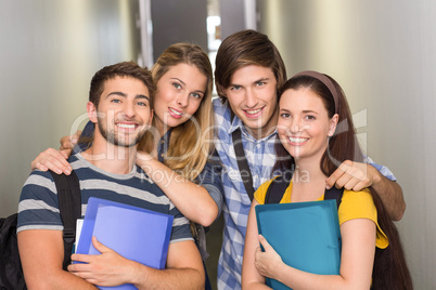 Students holding folders at college corridor