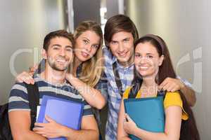 Students holding folders at college corridor