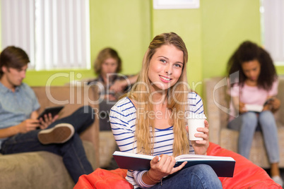 Casual young woman reading book in office