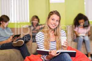 Casual young woman reading book in office