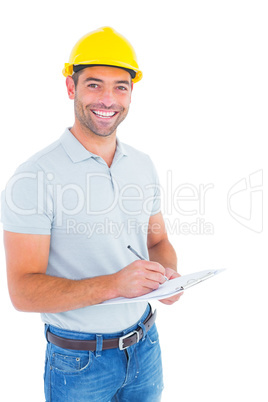 Portrait of smiling male supervisor writing on clipboard