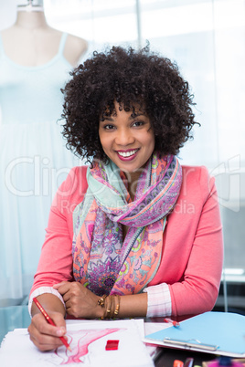 Female fashion designer sketching at table