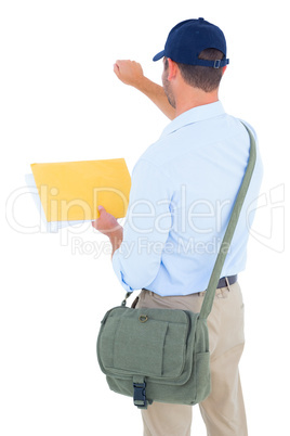 Postman with letter knocking on white background