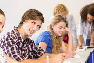 Students writing notes in classroom