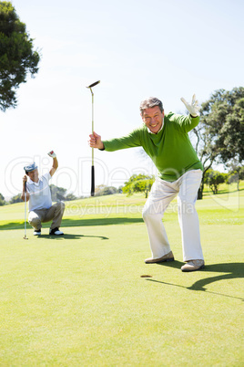 Golfing friends cheering on the putting green